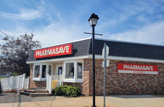 Brown-brick building with red Pharmasave signage at front