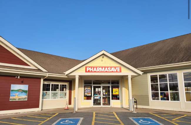 White 1-storey building with Pharmasave signage and two emptry accessible parking spaces directly out front