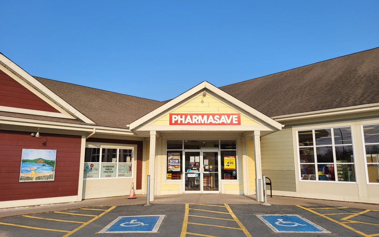 White 1-storey building with Pharmasave signage and two emptry accessible parking spaces directly out front