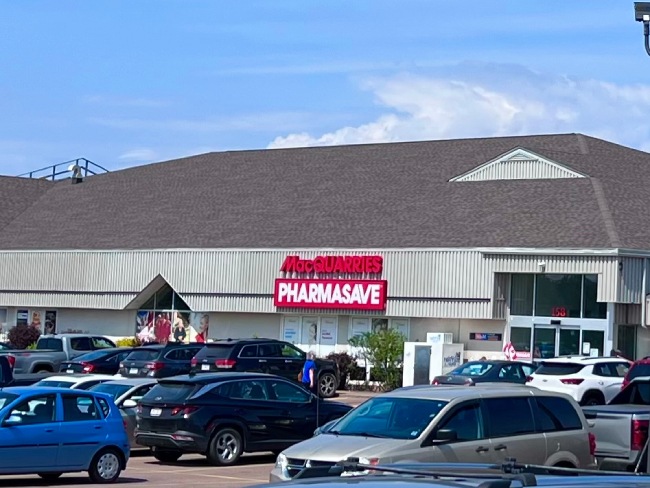 Multiple cars parked infront of a pharmacy