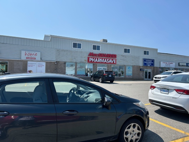 Car parked in front of entry of pharmacy